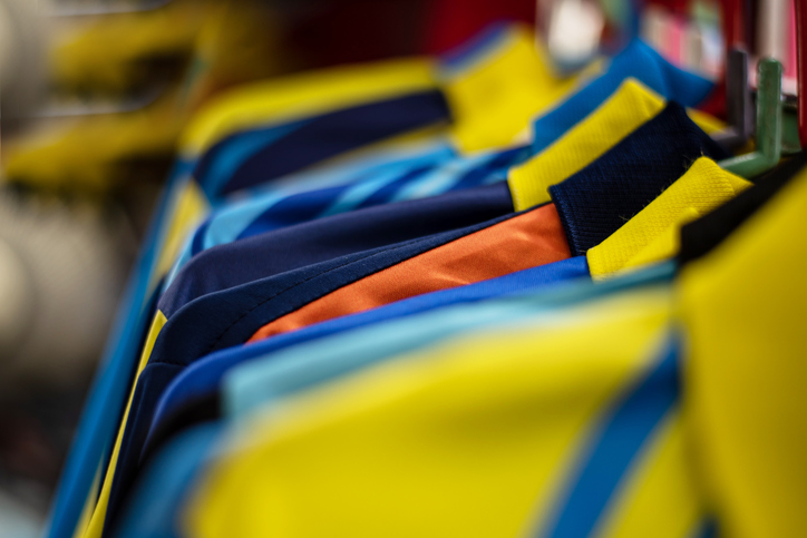 Uniforms neatly hung on racks with labeled bins below